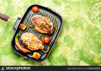 Whole chicken breast with spices on frying pan.Summer BBQ. Grilled healthy chicken breasts