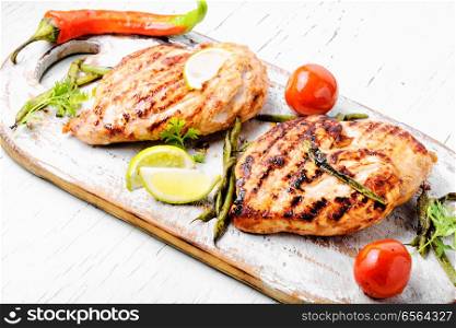 Whole chicken breast with spices on kitchen board.Summer BBQ. Roast chicken breast with lime