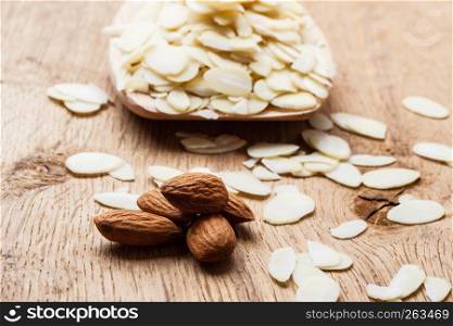 Whole food, good for health. Sliced blanched almonds and seeds on wooden kitchen board background