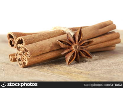 whole fragrant cinnamon sticks and star anise containing together on an old wooden cutting board. cinnamon and anise