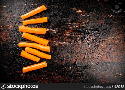 Whole fresh carrots on the table. On a rustic dark background. High quality photo. Whole fresh carrots on the table.