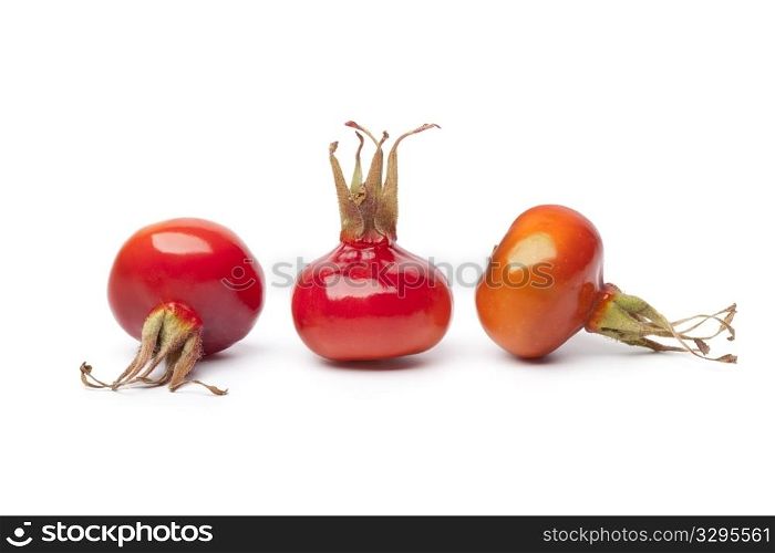 Whole fresh red rose hips isolated on white background