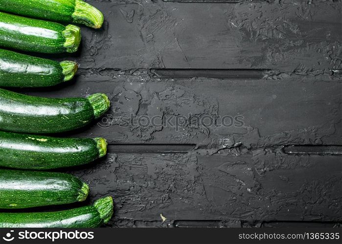 Whole fresh zucchini. On black rustic background. Whole fresh zucchini.