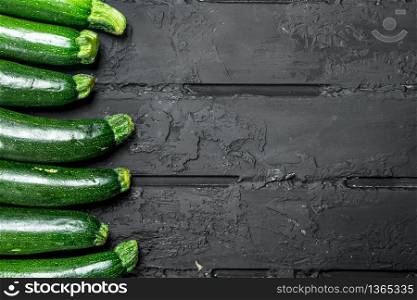 Whole fresh zucchini. On black rustic background. Whole fresh zucchini.