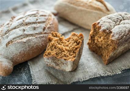 Whole grain breads on the dark wooden background
