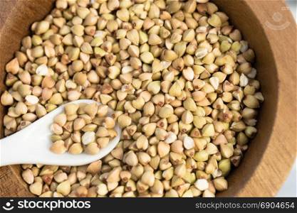 Whole grain buckwheat in wood bowl white spoon