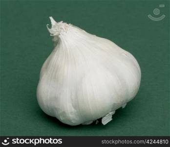 Whole head of garlic on green background
