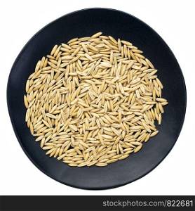 whole, organic oat groats - top view of an isolated black plate