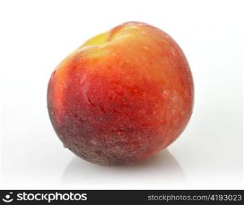 whole peach on white background with waterdrops