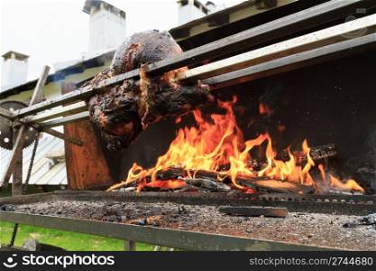 whole pork grilled on a spit outdoor