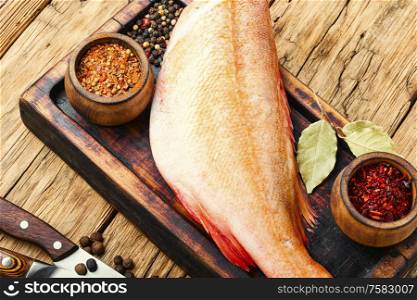 Whole raw fresh red perch or seabass.Raw fish on wooden background.Fresh fish seabass.. Fresh raw sea bass