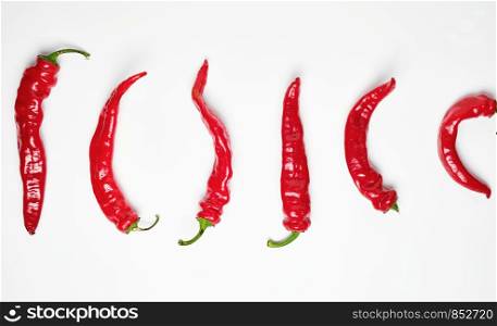 whole ripe red hot chili peppers on a white background, concept of distinction and discrimination