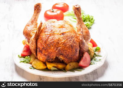 Whole Roasted Chicken on a plate with fried potatoes