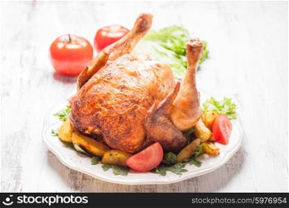 Whole Roasted Chicken on a plate with fried potatoes. The roasted chicken