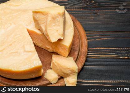 Whole round Head and pieces of parmesan or parmigiano hard cheese. Whole round Head and pieces of parmesan or parmigiano