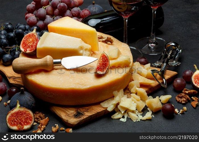 Whole round Head of parmesan or parmigiano hard cheese and wine on concrete background or table. Whole round Head of parmesan or parmigiano hard cheese and wine
