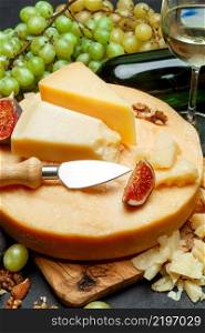 Whole round Head of parmesan or parmigiano hard cheese and wine on concrete background or table. Whole round Head of parmesan or parmigiano hard cheese and wine