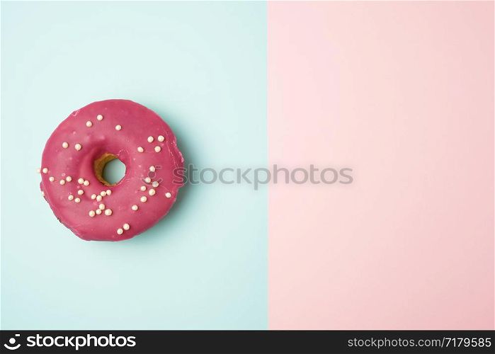 whole round red donut with sprinkles lie on a blue-pink background, top view, pastel colors