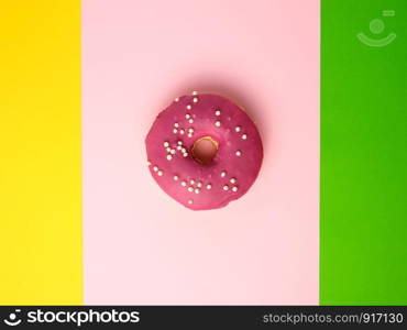 whole round red donut with sprinkles lie on a color background, top view