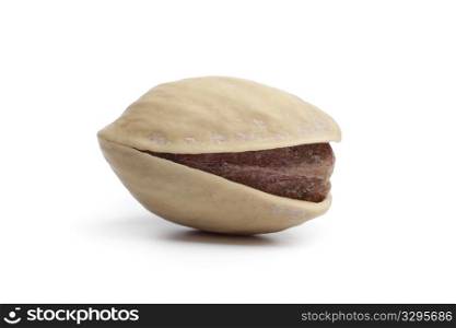 Whole single salted pistachio nut on white background