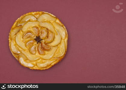 Whole tarte Tatin apple and pear tart pie isolated on claret background with copy space