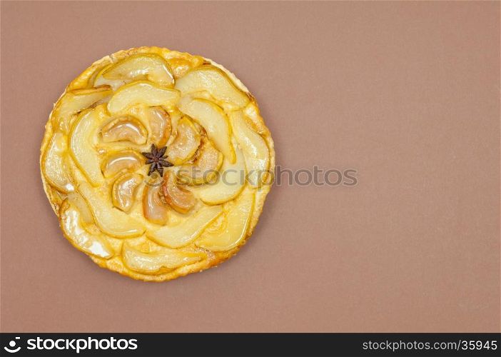 Whole tarte Tatin apple and pear tart pie isolated on light brown background with copy space