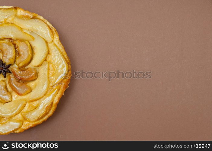 Whole tarte Tatin apple and pear tart pie isolated on light brown background with copy space