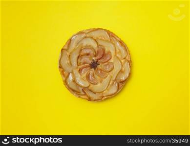 Whole tarte Tatin apple and pear tart pie isolated on yellow background with copy space
