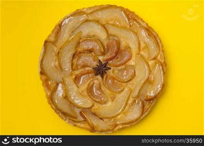 Whole tarte Tatin apple and pear tart pie isolated on yellow background with copy space