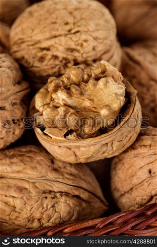 Whole walnuts and walnut kernel in a wicker basket close-up