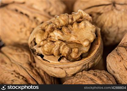 Whole walnuts and walnut kernel in a wicker basket close-up