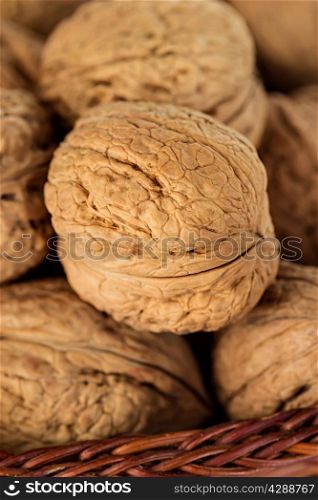 Whole walnuts in a wicker basket close-up