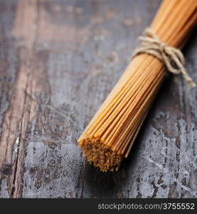 whole wheat spaghetti on wooden background
