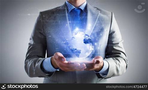 Whole world in hands. Close up of businessman holding digital globe in palm