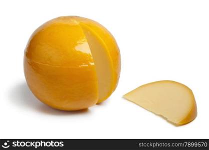 Whole yellow round Edam cheese with a slice on white background
