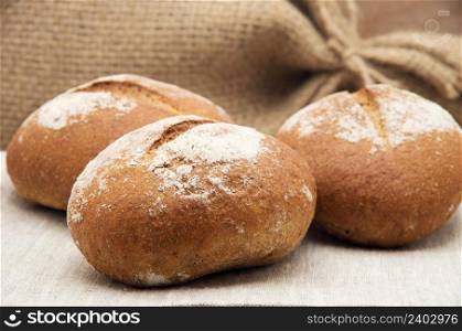 Wholemeal bread rolls on a tea towel
