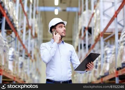 wholesale, logistic, business, export and people concept - businessman with clipboard calling on smartphone at warehouse