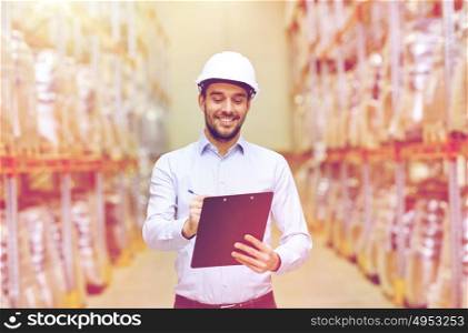 wholesale, logistic, business, export and people concept - happy man or manager with clipboard checking goods at warehouse. happy businessman with clipboard at warehouse