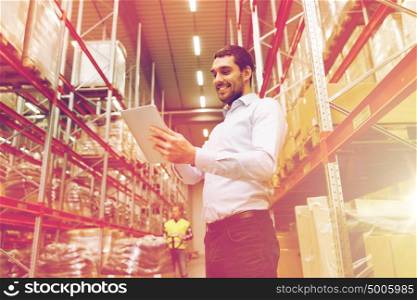 wholesale, logistic, business, export and people concept - happy man or manager with tablet pc computer checking goods at warehouse. happy businessman with tablet pc at warehouse