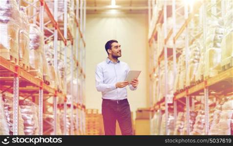 wholesale, logistic, business, export and people concept - happy man or manager with tablet pc computer checking goods at warehouse. happy businessman with tablet pc at warehouse