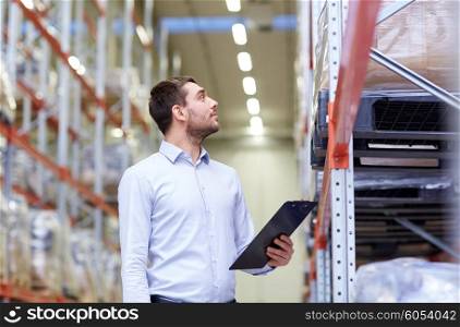 wholesale, logistic, business, export and people concept - happy man or manager with clipboard checking goods at warehouse