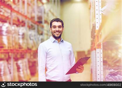 wholesale, logistic, business, export and people concept - happy man or manager with clipboard at warehouse. happy businessman with clipboard at warehouse