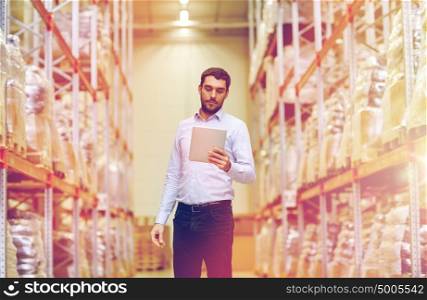 wholesale, logistic, business, export and people concept - man or manager with tablet pc computer checking goods at warehouse. businessman with tablet pc at warehouse