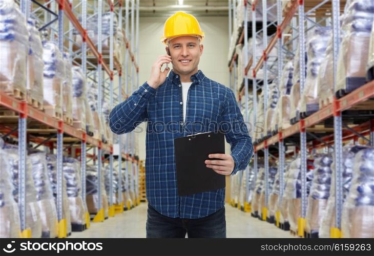 wholesale, logistic, business, export and people concept - smiling businessman with clipboard calling on smartphone over warehouse background