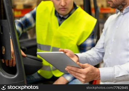 wholesale, logistic, loading, shipment and people concept - close up of loader on forklift and businessman with tablet pc computer at warehouse. men with tablet pc and forklift at warehouse