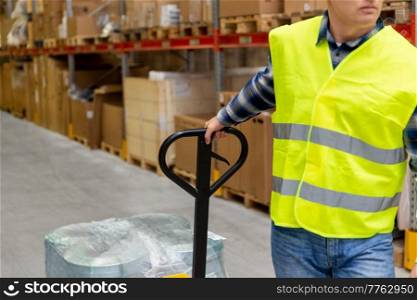 wholesale, logistic, loading, shipment and people concept - close up of man with loader working at warehouse. man with loader working at warehouse