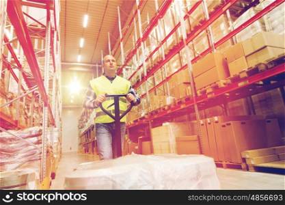 wholesale, logistic, loading, shipment and people concept - man carrying loader with goods at warehouse