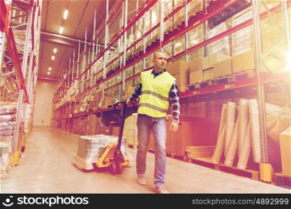 wholesale, logistic, loading, shipment and people concept - man carrying loader with goods at warehouse
