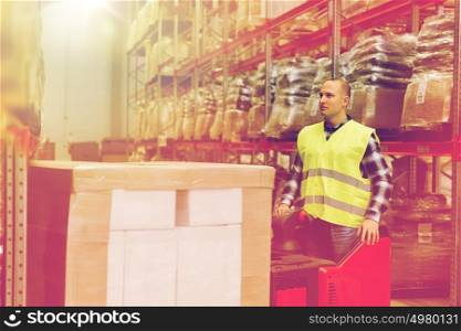 wholesale, logistic, loading, shipment and people concept - man or loader on forklift loading cargo at warehouse. man on forklift loading cargo at warehouse