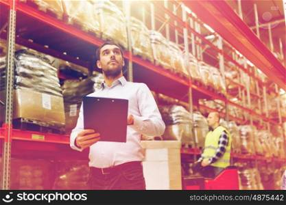 wholesale, logistic, people and export concept - businessman with clipboards at warehouse